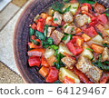Clay plate with mix colourful vegetable soup or stew and crackers top view 64129467