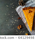 A piece of pumpkin cheesecake on white crumpled paper on a black granite chalkboard with text space 64129498