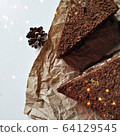 A pieces of chocolate brownie on a crumpled paper with bokeh lights 64129545