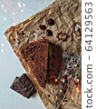A piece of brownie and chocolate candies on a crumpled paper with bokeh lights 64129563