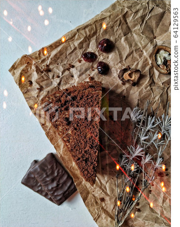 A piece of brownie and chocolate candies on a crumpled paper with bokeh lights A piece of brownie and chocolate candies on a crumpled paper with bokeh lights 64129563