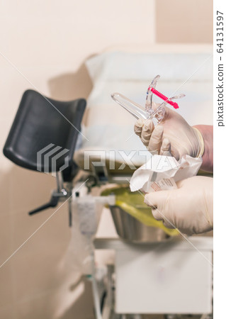 Close-up of doctor hand holds gynecological examination instruments. Gynecologist working in the obstetrics and gynecology department. Medical concept. 64131597