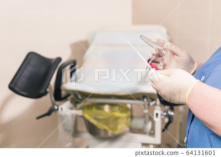 Close-up of doctor hand holds gynecological examination instruments. Gynecologist working in the obstetrics and gynecology department. Medical concept. 64131601