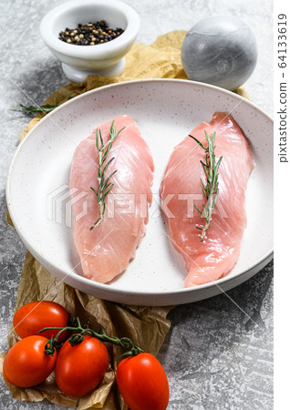 Turkey fillet in a white ceramic plate. Gray background. Top view Turkey fillet in a white ceramic plate. Gray background. Top view 64133619