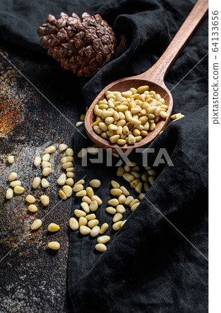 Pine nuts on stone table. Black background. Top view Pine nuts on stone table. Black background. Top view 64133656