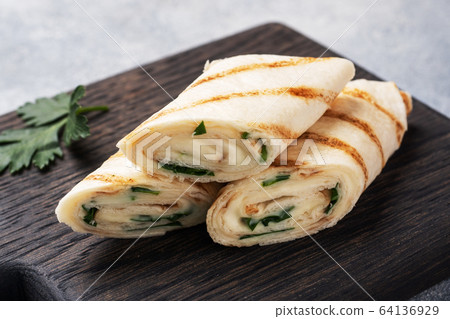 Roll with cheese and herbs. Grilled pita bread 64136929