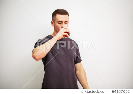 Man takes a pill of amino acids after training. Man takes a pill of amino acids after training. 64137092