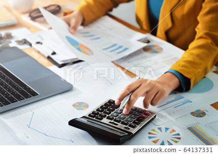 Woman accountant use calculator and computer with Woman accountant use calculator and computer with 64137331