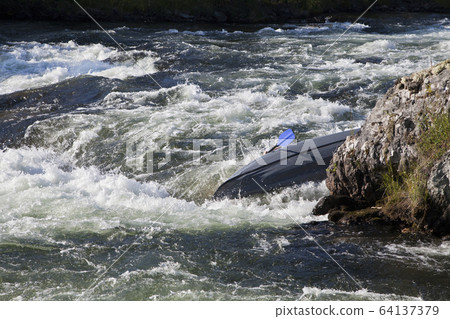 Kayaker turning over in whitewater 64137379