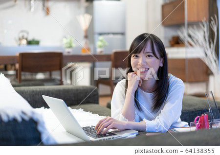 Young woman playing computer at home Young woman playing computer at home 64138355
