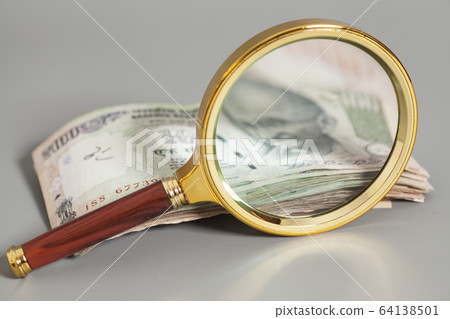 Indian Currency Rupee Notes with magnifying glass Indian Currency Rupee Notes with magnifying glass 64138501