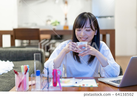年輕女子在家裡喝茶 年輕女子在家裡喝茶 64138502