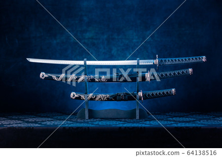 Three swords on stand, katana blade exposed, blue 64138516