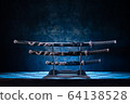 Three swords on stand, with dramatic blue light 64138528