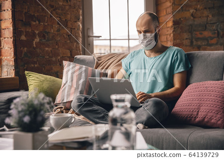 Young man doing yoga at home while being quarantine and freelance working 64139729