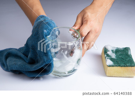 washing clear glass by bare hand and blue rag sponge foam on white background stock photo washing clear glass by bare hand and blue rag sponge foam on white background stock photo 64140388