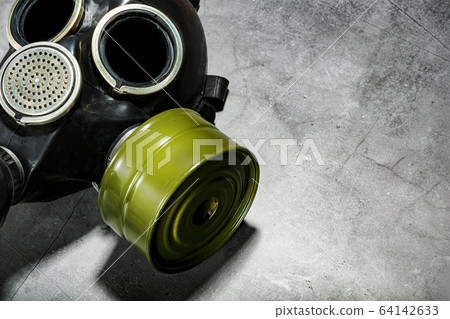 Gas mask on a black stone background, protection from dangerous infection. Gas mask on a black stone background, protection from dangerous infection. 64142633