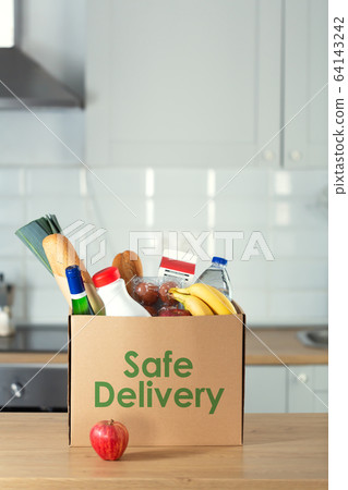 Safe home delivery. A box of food on the modern kitchen Safe home delivery. A box of food on the modern kitchen 64143242
