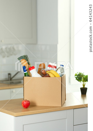Safe home delivery. A box of food on the modern kitchen Safe home delivery. A box of food on the modern kitchen 64143243