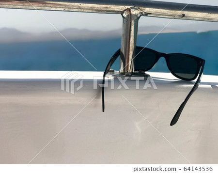 Black plastic sunglasses hang on an iron Black plastic sunglasses hang on an iron 64143536