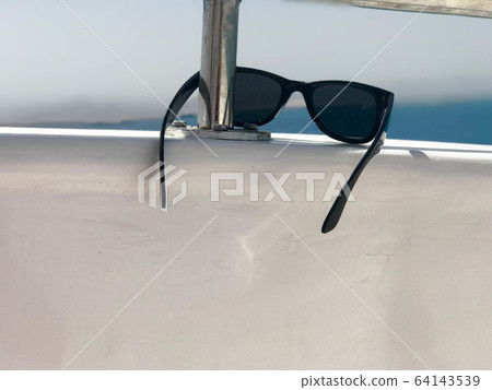 Black plastic sunglasses hang on an iron Black plastic sunglasses hang on an iron 64143539