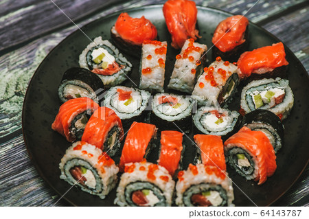 Various kinds of sushi served on dark plate macro Various kinds of sushi served on dark plate macro 64143787