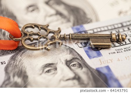 Closeup of key on hundred dollar bills Closeup of key on hundred dollar bills 64143791