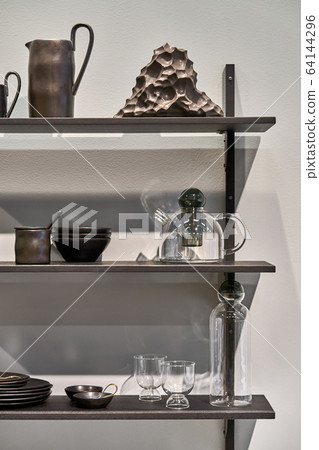 Luminous interior with dark shelves with dishes Luminous interior with dark shelves with dishes 64144296