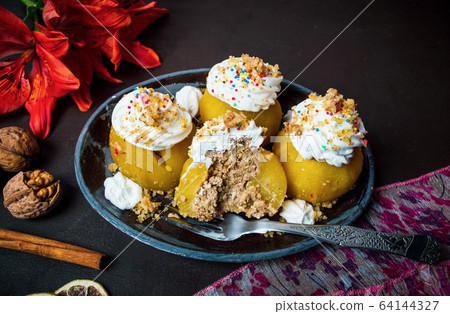 Poached apple with whipped cream and walnuts 64144327