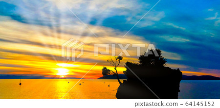 Dramatic sunset over the Adriatic Sea with Kamen Brela in Brela, Makarska Riviera, Croatia Dramatic sunset over the Adriatic Sea with Kamen Brela in Brela, Makarska Riviera, Croatia 64145152