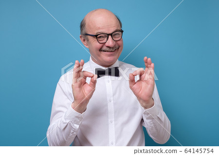 Caucasian man in white shirt smiling on camera with alright ok sign Caucasian man in white shirt smiling on camera with alright ok sign 64145754