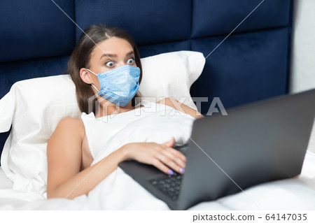 Shocked Lady Using Laptop Wearing Mask Lying In Bed Indoor Shocked Lady Using Laptop Wearing Mask Lying In Bed Indoor 64147035