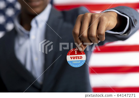 Unrecognizable african citizen of America holds I voted today 64147271
