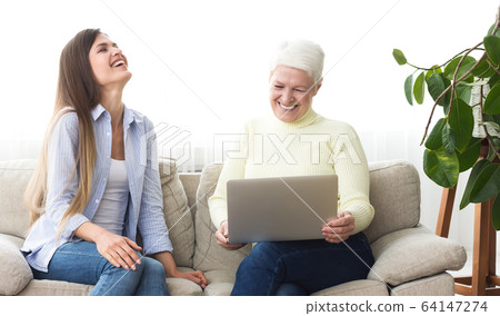 Mother and daughter watching funny videos on laptop Mother and daughter watching funny videos on laptop 64147274