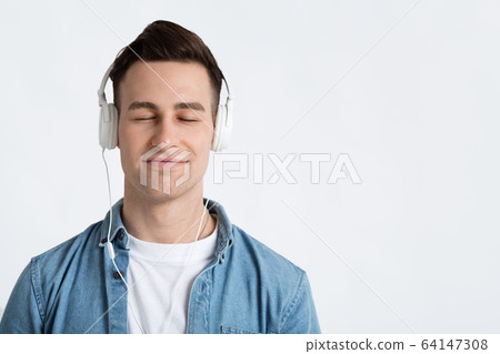 Man closed eyes, enjoys music on headphones 64147308