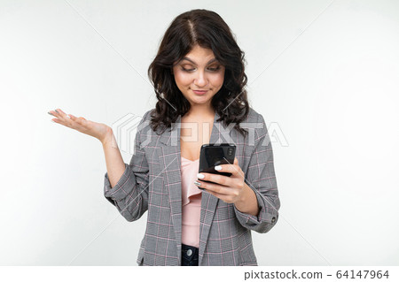 brunette girl indignantly studies information from the phone on a white studio background brunette girl indignantly studies information from the phone on a white studio background 64147964