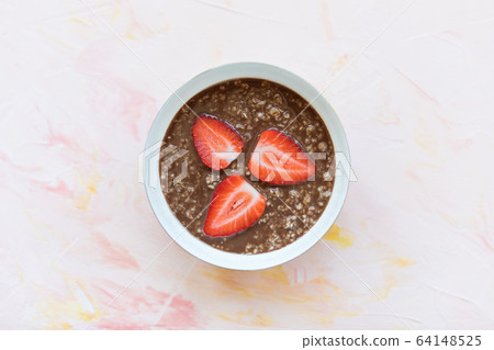 Chocolate oatmeal porridge and strawberry in bowl 64148525