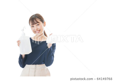 Young woman disinfecting mask with alcohol 64149768