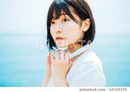 Woman listening to music at sea 64150740