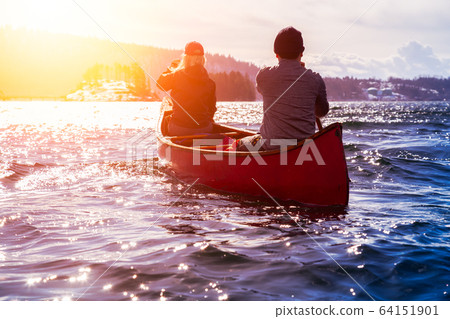 Canoeing during vibrant Sunset 64151901
