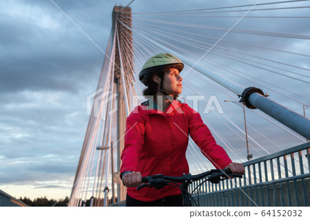 Caucasian Woman riding a Bicycle on a path at Port Mann Bridge 64152032