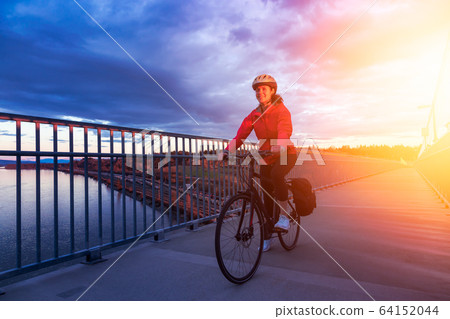 Caucasian Woman riding a Bicycle on a path at Port Mann Bridge 64152044