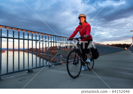 Caucasian Woman riding a Bicycle on a path at Port Mann Bridge 64152046