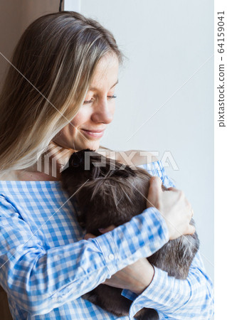 Pet and Easter concept - Happy girl hugging brown rabbit at home. 64159041