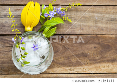 background texture purple flower ,yellow flower ylang ylang and iced water in glass arrangement flat lay postcard style background texture purple flower ,yellow flower ylang ylang and iced water in glass arrangement flat lay postcard style 64161511