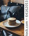 Pancakes with honey on wooden tray in cozy room. 64162053