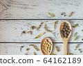 Herbal pills and dry herbs on wooden background. 64162189