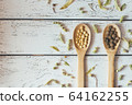 Herbal pills and dry herbs on wooden background. 64162255