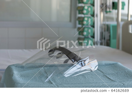 Three plastic protective shields on table in ICU in hospital, personal protective equipment to protect against the virus  covid-19. 64162689