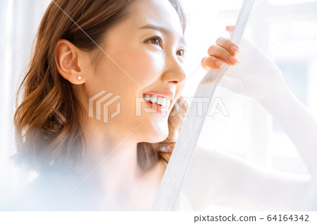 美麗的女人明亮的房間室內窗簾微笑人素材 64164342